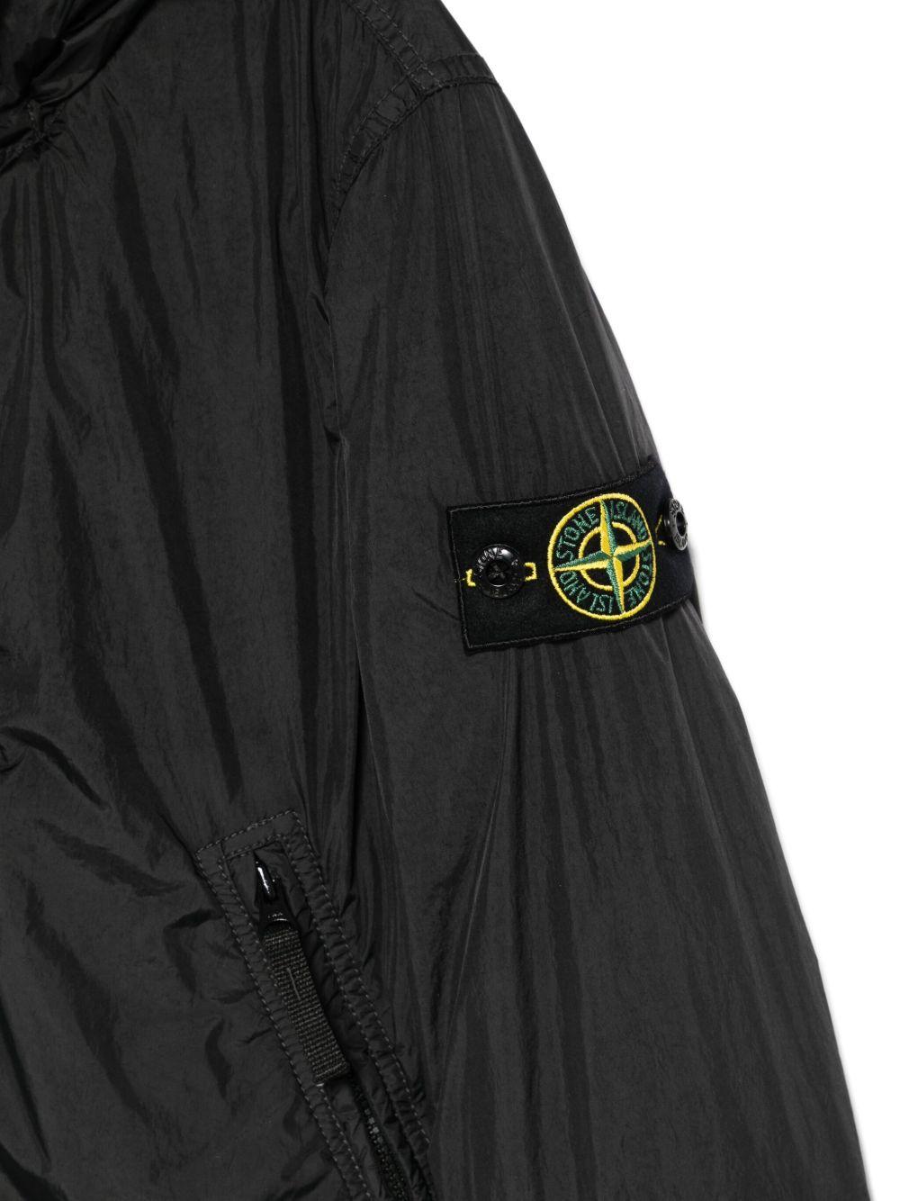Giacca per bambino Stone Island Junior nero con cappuccio e toppa con logo - Rubino Kids