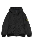 Giacca per bambino Stone Island Junior nero con cappuccio e toppa con logo - Rubino Kids