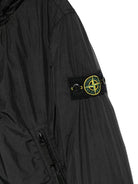 Giacca per bambino Stone Island Junior nero con cappuccio e toppa con logo - Rubino Kids