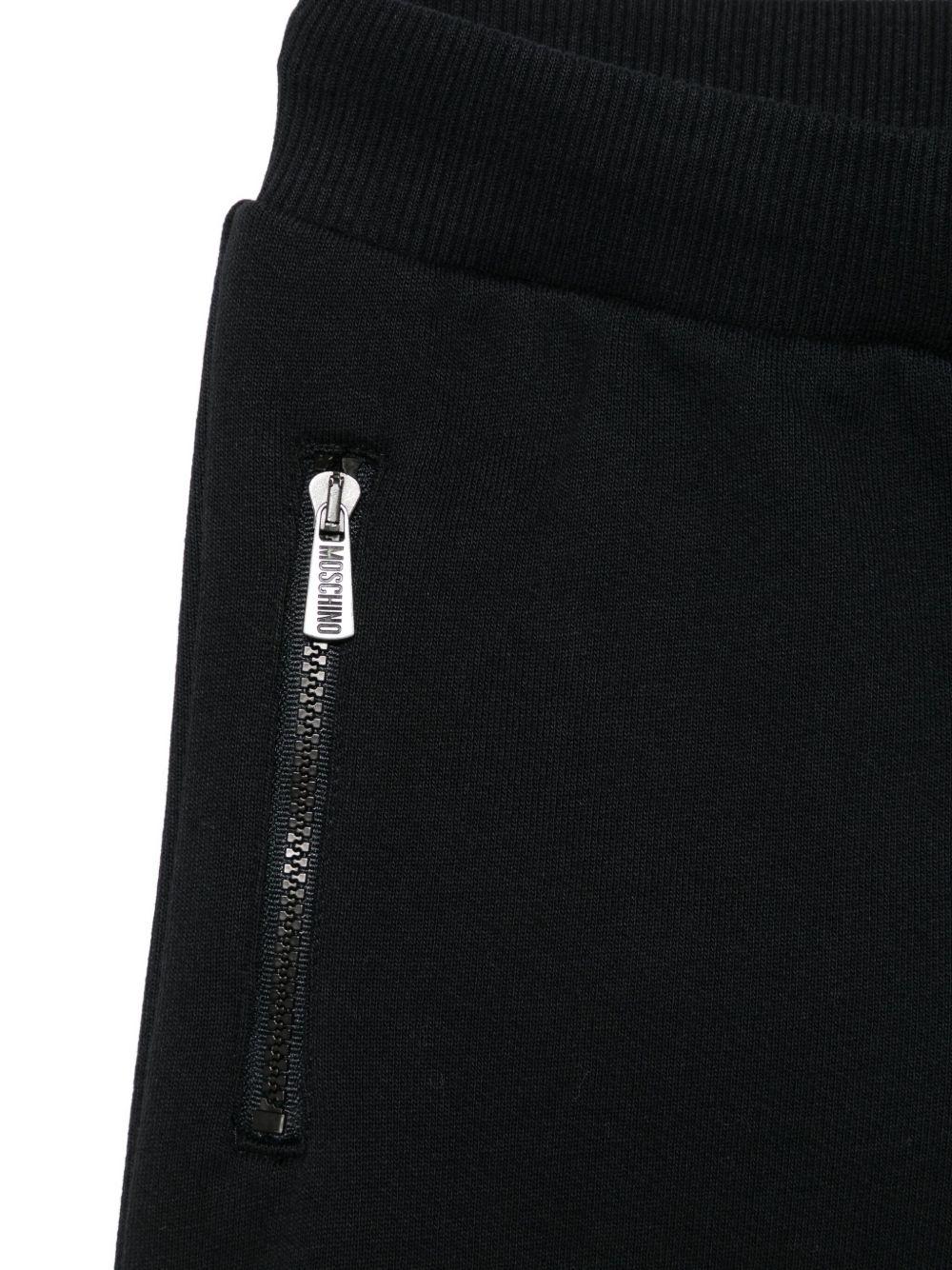 Pantaloni sportivi per bambino Moschino Kids nero con stampa Teddy Bear - Rubino Kids