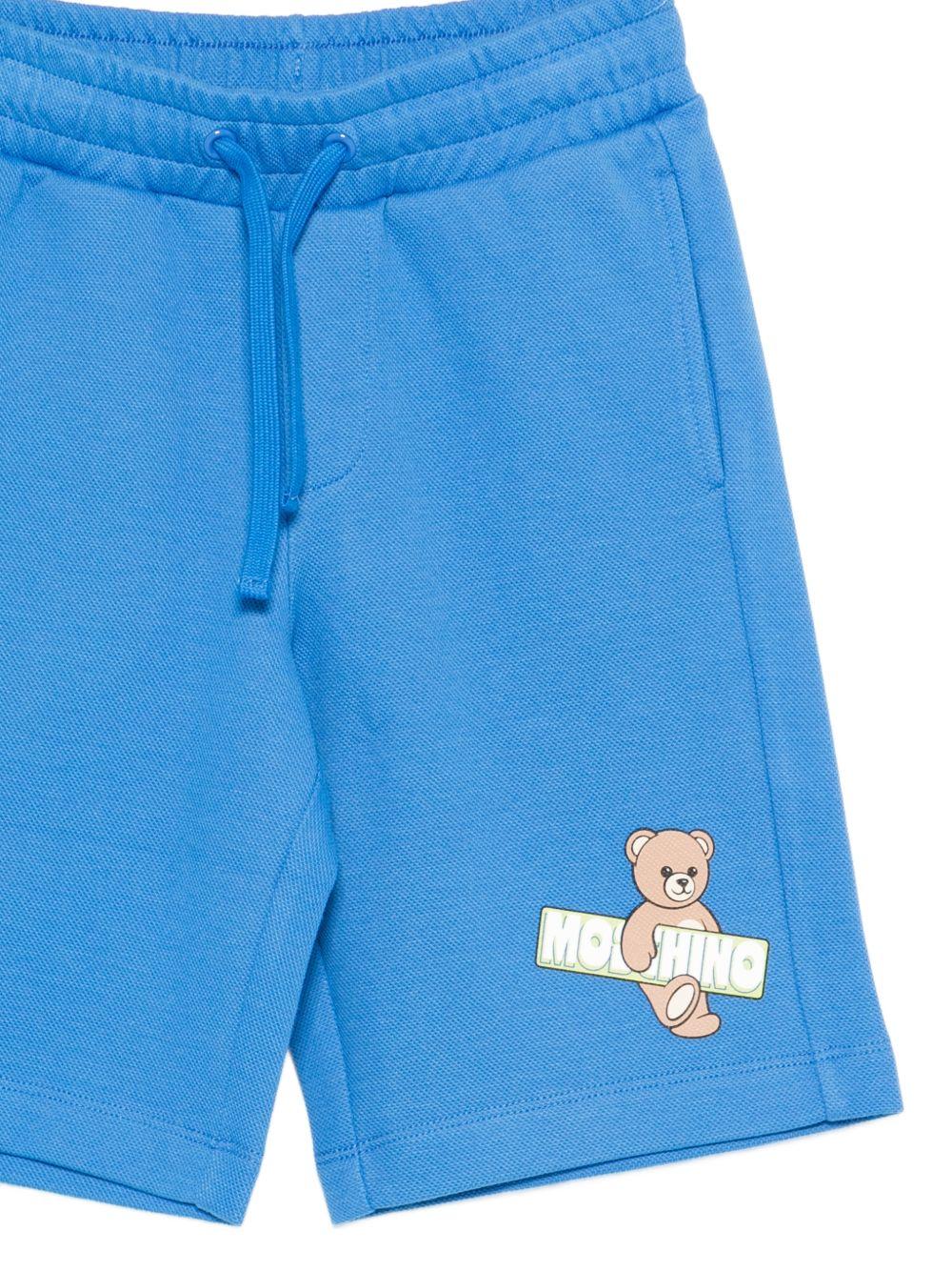 Shorts per bambino Moschino Kids azzurri con logo sul davanti - Rubino Kids