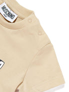 T-shirt per neonati Moschino Kids beige con logo sul davanti - Rubino Kids